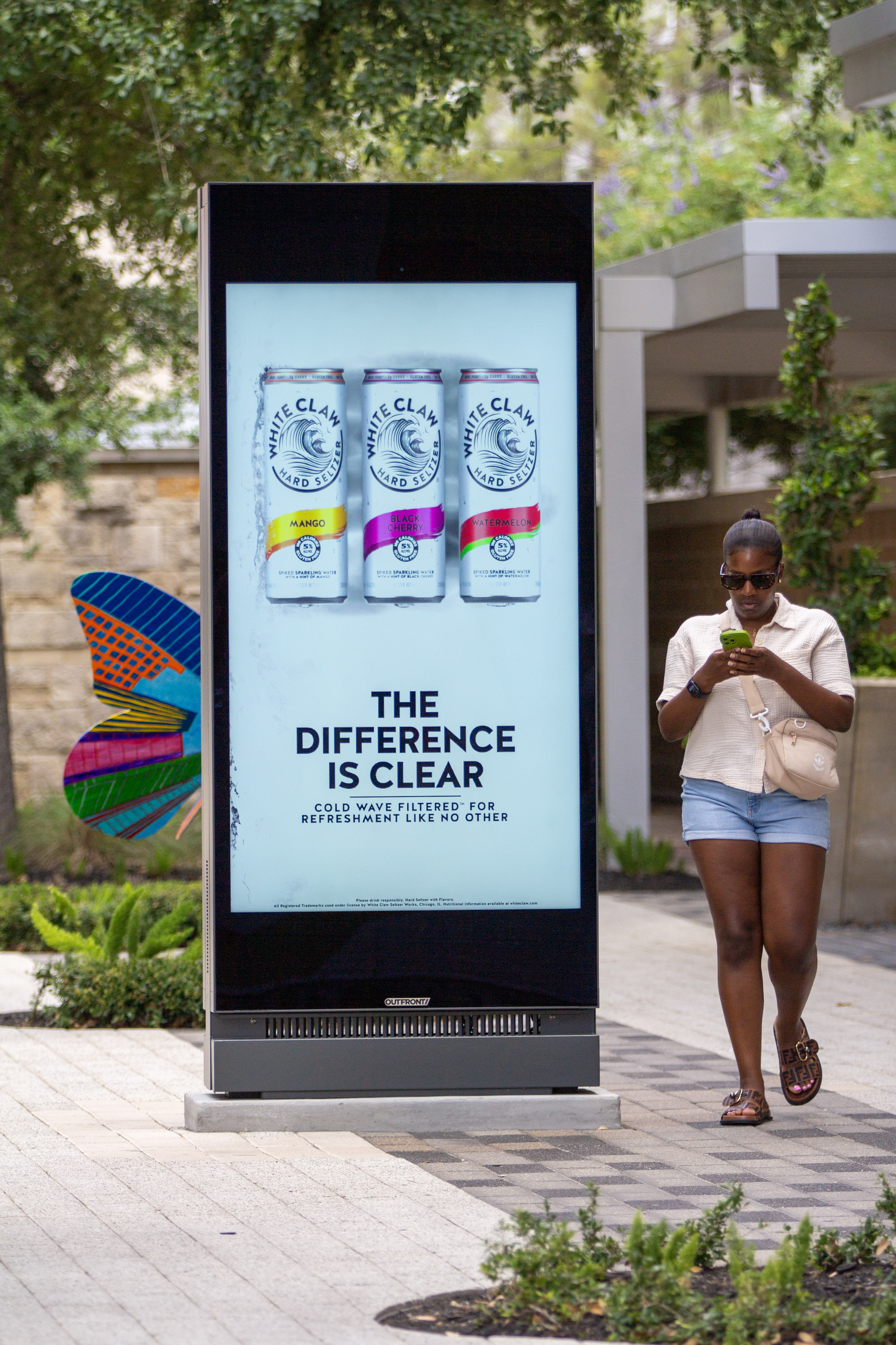 Young woman walking past a Placard 75 Houston CityCentre.jpg